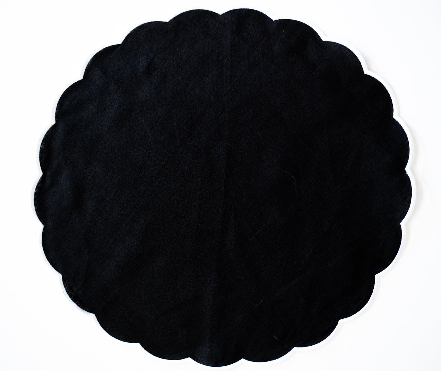 Black round scalloped linen napkin with white trim