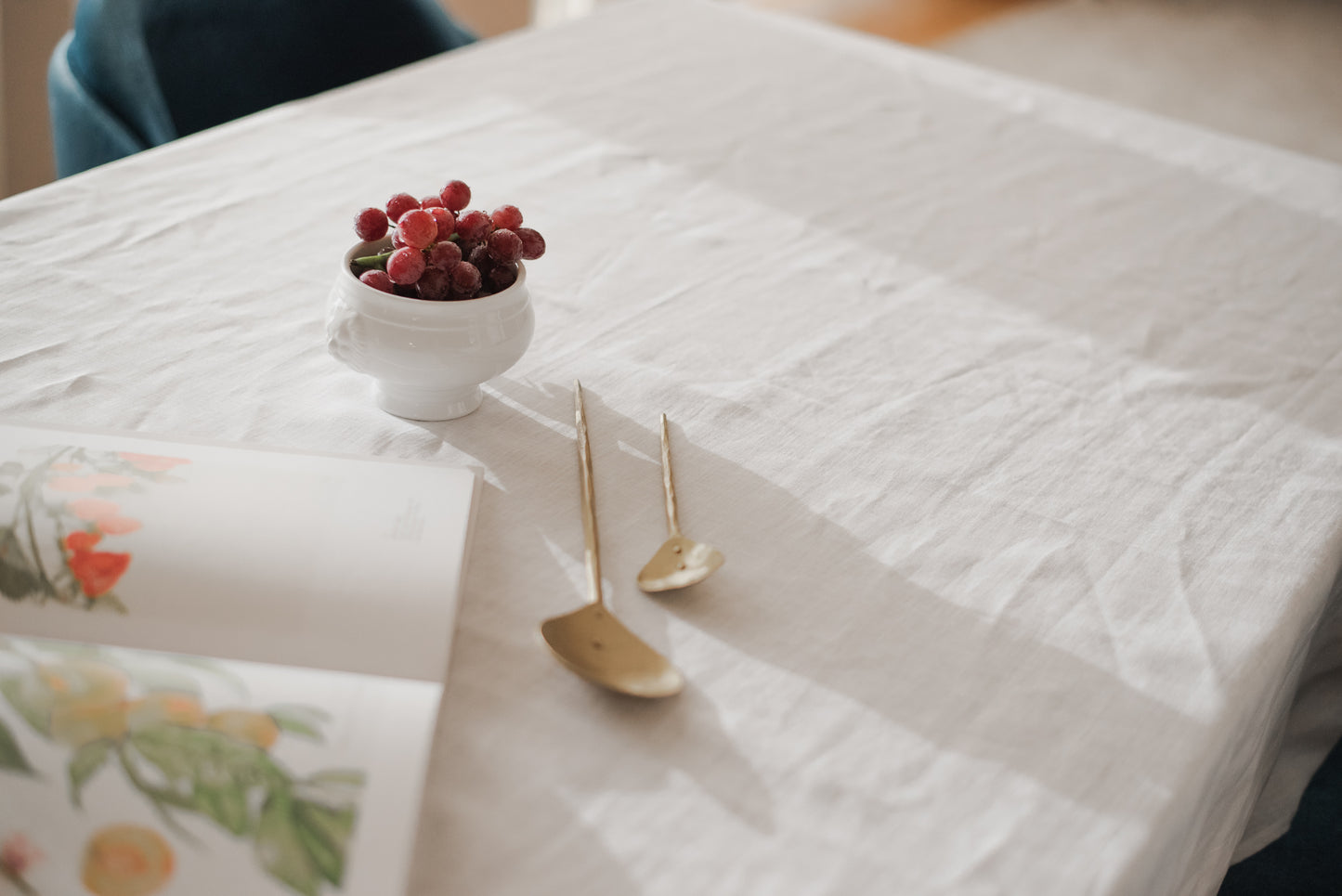 Beautiful golden serving spoons high quality on a sustainable pure linen white tablecloth